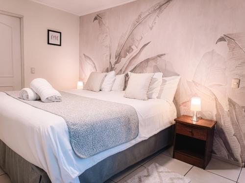 a bedroom with a large bed with a painting on the wall at Hostal del Rio Talca in Talca