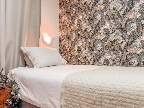 a small bedroom with a bed with a wallpaper at Hostal del Rio Talca in Talca