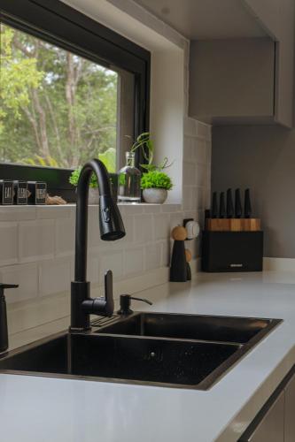 a kitchen with a black sink and a window at Casa Sebas at Riviera Maya in Xpu Ha