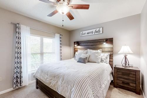 a bedroom with a bed with a ceiling fan and a window at Cedar Lodge #503 in Pigeon Forge