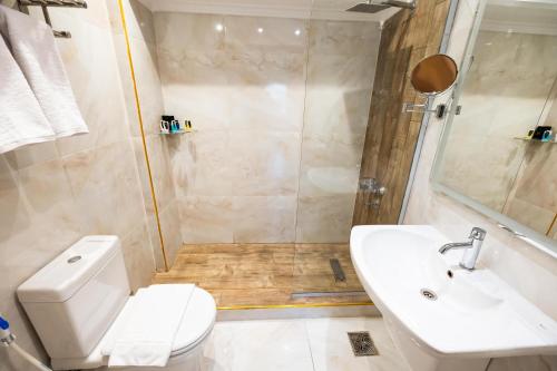 a bathroom with a toilet and a sink and a shower at Golden Park Hotel Cairo, Heliopolis in Cairo