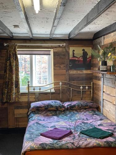 a bed sitting in a room with a window at Hayloft Sleep 2 NeXT to Fox Covert Pub in Kirk Leavington
