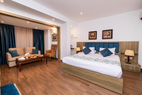 a hotel room with a large bed and a table at Golden Park Hotel Cairo, Heliopolis in Cairo