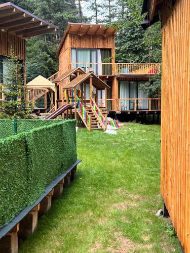 a house with a playground in front of a yard at ECHIVITI Cottages in Abastumani in Abastumani