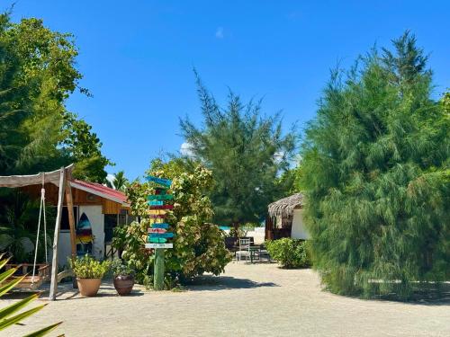 a grouping of beach towels on a pole next to trees at Noah Private Beach House in Himmafushi