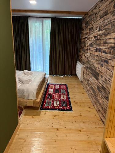 a bedroom with a bed and a brick wall at ECHIVITI Cottages in Abastumani in Abastumani
