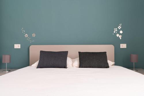 a bedroom with a white bed with two black pillows at La casa di AnNa in Cervesina