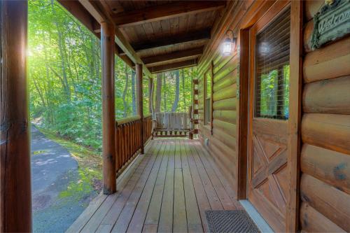 a wooden porch on a cabin in the woods at Rosey Bear cabin in Pittman Center