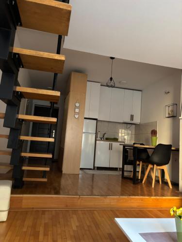 a kitchen and a living room with a spiral staircase at Mia’s duplex apartment in Skopje