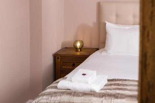 a bedroom with a bed with towels on it at The Highland Club in Fort Augustus