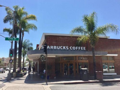 a building on a street with palm trees in front of it at Cozy&Stylish DT Alhambra Living walk to Starbucks in Alhambra