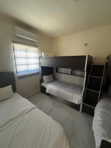 a bedroom with two bunk beds and a window at شاليه هاف مليون الرامة in Al Mazār