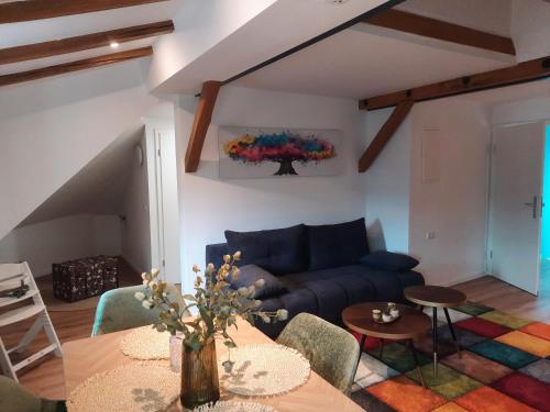 a living room with a blue couch and a table at FeWo A 6 J 22 Michelangelo NETFLIX Fußgängerzone in Eisenach