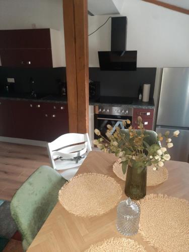 a dining room table with a vase of flowers on it at FeWo A 6 J 22 Michelangelo NETFLIX Fußgängerzone in Eisenach