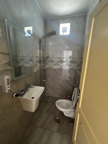 a bathroom with a sink and a toilet and a shower at شاليه هاف مليون الرامة in Al Mazār