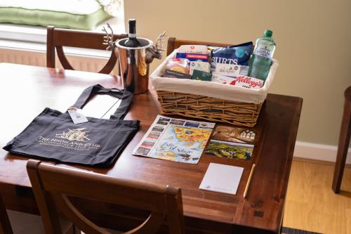 a table with a basket of food and a bag on it at The Highland Club in Fort Augustus