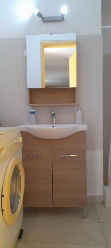 a bathroom with a sink and a mirror at Cosy guest house with private yard in Saronida