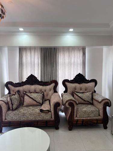 a living room with two chairs and a table at Spring den apartments in Rungiri