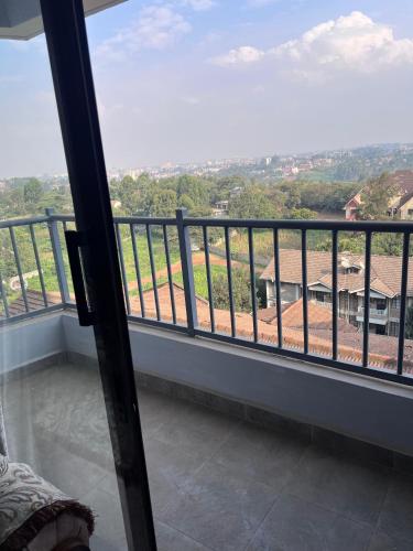 a room with a balcony with a view of the countryside at Spring den apartments in Rungiri