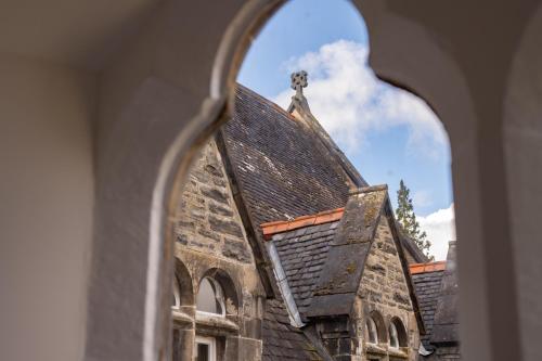 a view of a church through a window at The Highland Club in Fort Augustus
