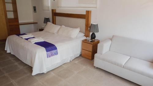 a bedroom with a white bed and a couch at Finca Catalina Hotel Boutique in Tepoztlán