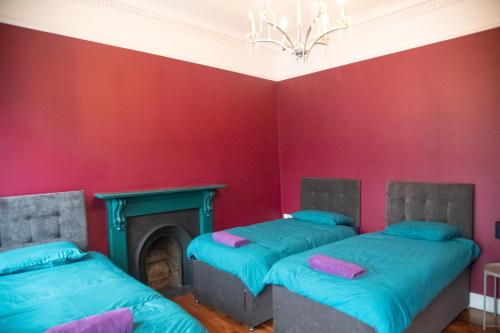 two beds in a room with a fireplace at Carrick Central Accommodation in Carrick on Shannon