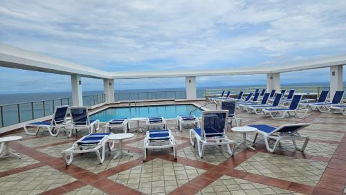 a balcony with chairs and a swimming pool on a cruise ship at Solarium Studio Apartment at Coronado Bay Oceanfront in Playa Coronado