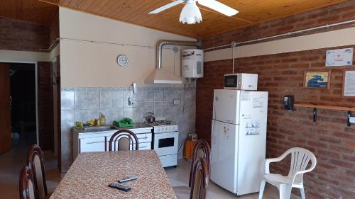 eine Küche mit einem weißen Kühlschrank und einem Tisch mit Stühlen in der Unterkunft Dptos Kandava San Antonio Este in San Antonio Este