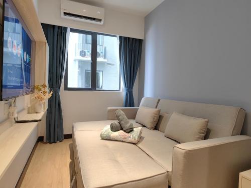 a living room with a couch with a pillow on it at Vetro11 Beside QEH1 by JUNE Homestay in Kota Kinabalu