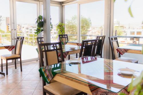 a dining room with a glass table and chairs at Ssamana María Apartment & Guesthouse in Arequipa