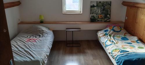 a room with two beds and a table and a window at maison bleue in Belfort