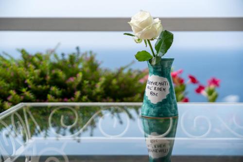 a white rose sitting in a green vase at Hotel Eden Roc in Positano