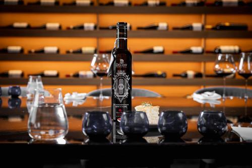 a bottle of beer sitting on a table with glasses at Hotel Eden Roc in Positano