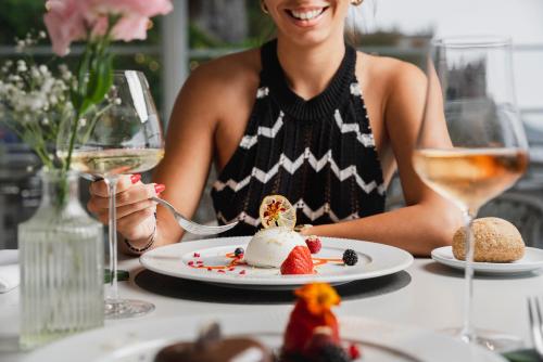 a woman sitting at a table with a plate of food at Hotel Eden Roc in Positano
