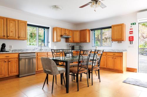 a kitchen with wooden cabinets and a table and chairs at Casa do Dízimo in Furnas