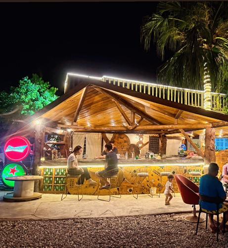 a group of people sitting under a tent at night at 近月旭海莊園民宿 in Yanliau