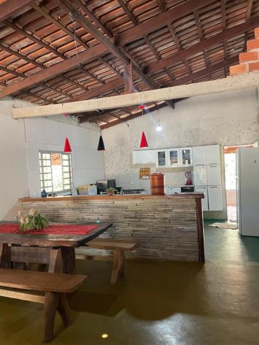 a kitchen with a table and benches in a room at Cantinho da Herança in Pirenópolis