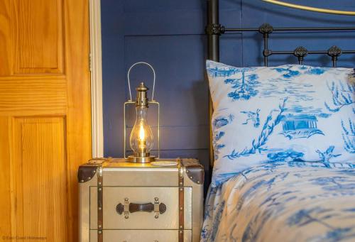 a bed with a lamp on a trunk next to it at Coastal home sleeping five - 2 minute walk beach in Pakefield