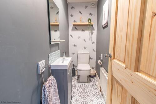 a small bathroom with a toilet and a sink at Coastal home sleeping five - 2 minute walk beach in Pakefield