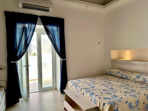 a bedroom with a bed and a sliding glass door at Domus Ɫ Ponza in Ponza