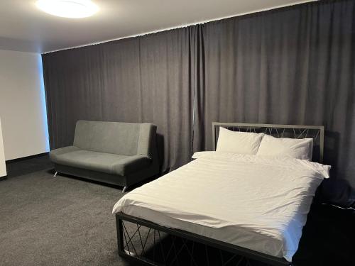 a bedroom with a bed and a chair at Дача in Kryvyi Rih