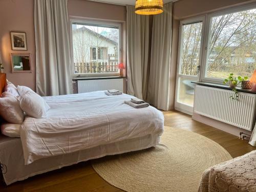 Un dormitorio con una cama y una ventana grande. en Large flat with own patio, en Nacka
