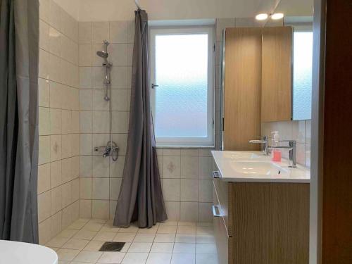 un baño con ducha y lavabo en Large flat with own patio, en Nacka