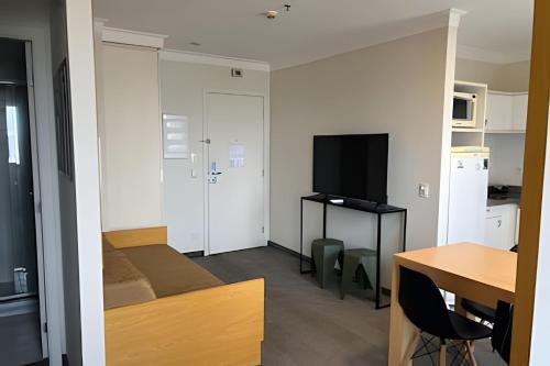 a small room with a bed and a table with a television at Airfamily Congonhas in Sao Paulo