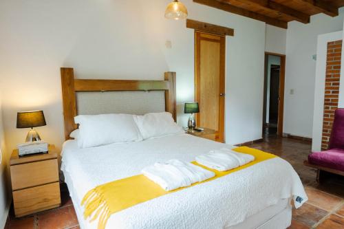 a bedroom with a bed with two towels on it at Finca Catalina Hotel Boutique in Tepoztlán