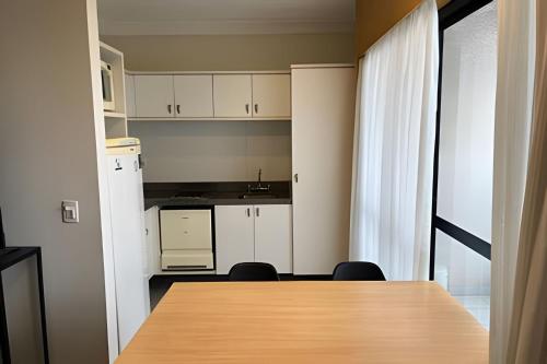 a kitchen with white cabinets and a table and chairs at Airfamily Congonhas in Sao Paulo
