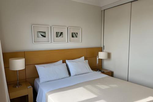 a bedroom with a bed and two pictures on the wall at Airfamily Congonhas in Sao Paulo