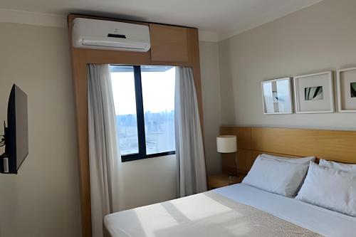 a hotel room with a bed and a window at Airfamily Congonhas in Sao Paulo