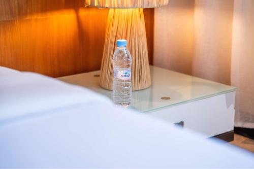 a bottle of water sitting on a table next to a lamp at Penthouse d'Exception, Terrasse et Piscine Privée in Bouznika