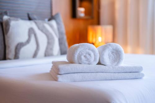 a pile of towels sitting on top of a bed at Penthouse d'Exception, Terrasse et Piscine Privée in Bouznika